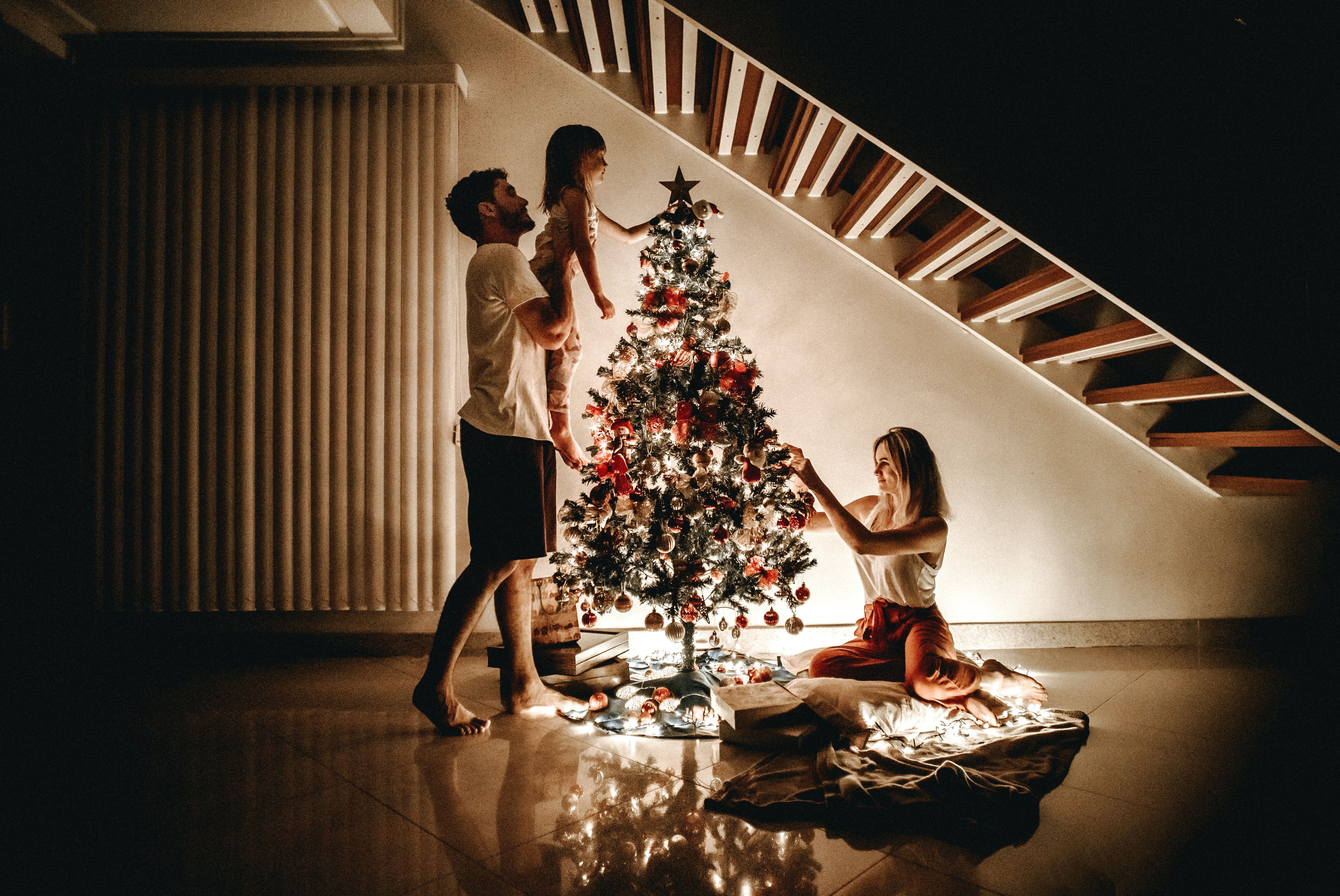 parents and child decorating holiday tree